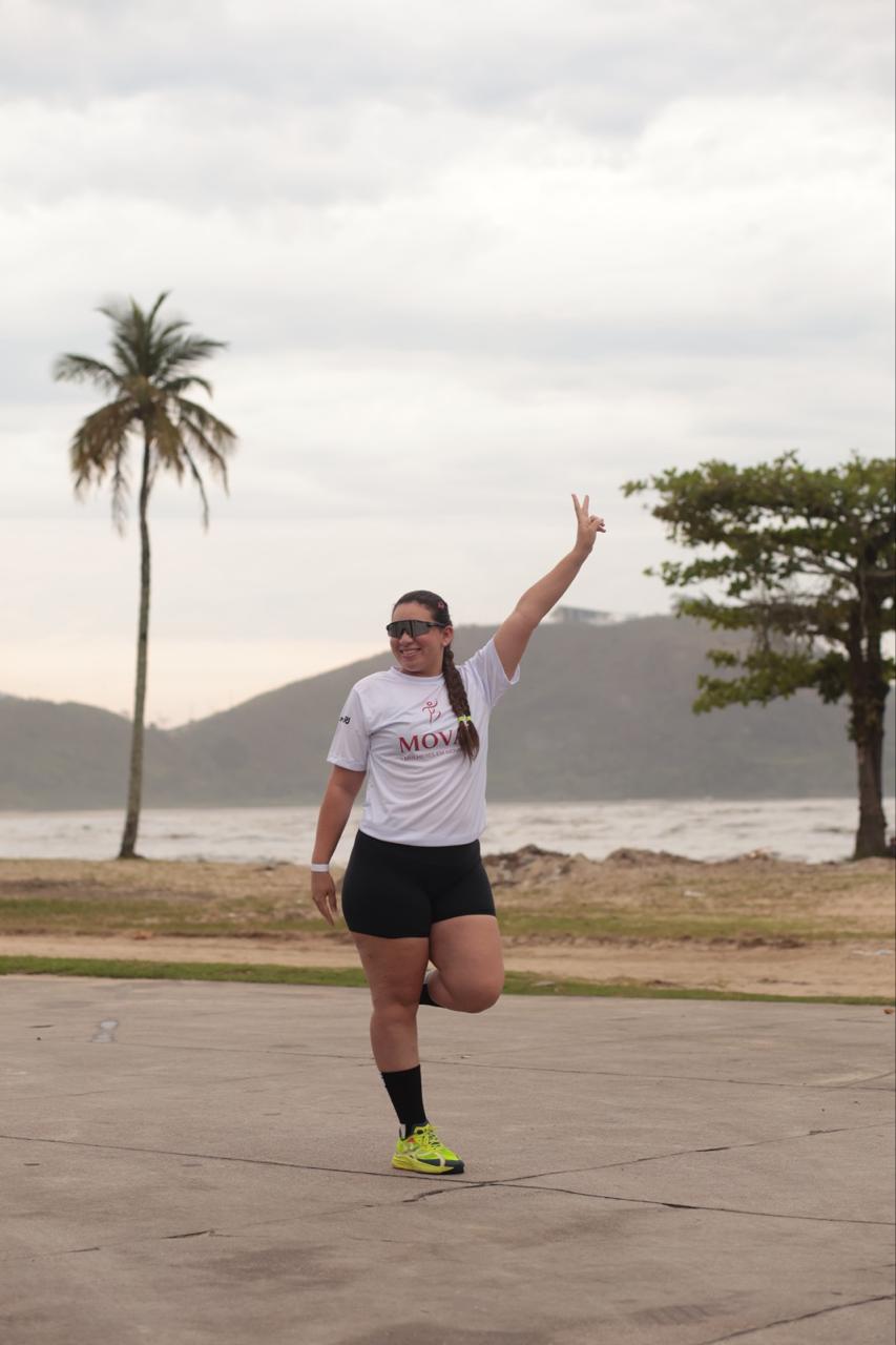 Participante celebrando à beira-mar durante o primeiro MOVAÊ Run